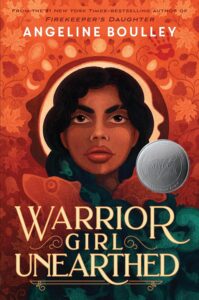 Cover of Warrior Girl Unearthed. Cover is orange with leaves, handprints and flowers. There is a woman's face in the center of the book, with dark hair, dark eyes and a serious look. The bottom of the cover is green, and has a pattern of interlocking fish.