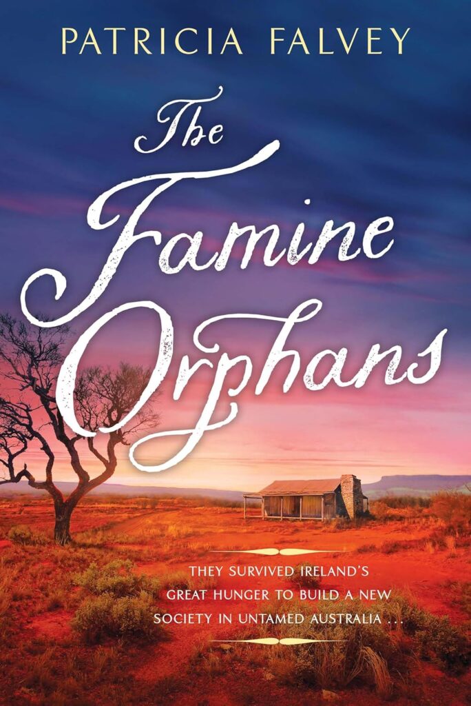 Cover of The Famine Orphans. Cover is illustration of the Australian Outback. There is a bushy foreground, a small house, mountains in the distance, and a beautiful pink and purple sky that dominates most of the cover.