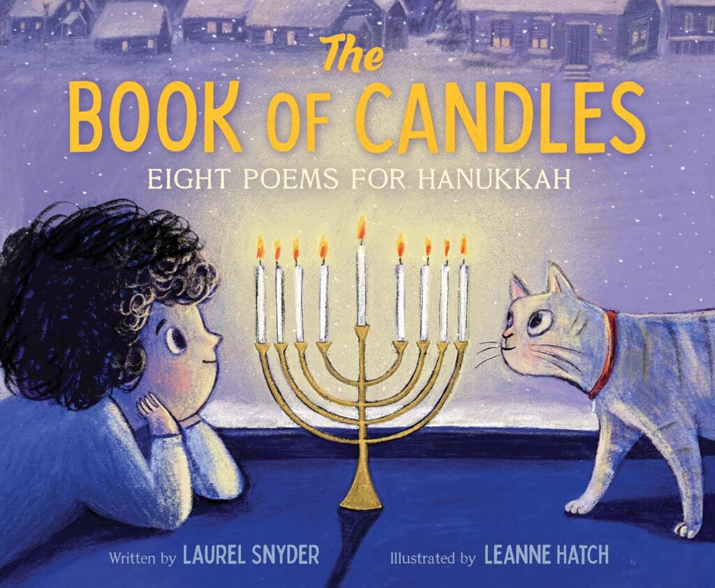 Cover of The Book Of Candles. There is a child looking at a menorah in the window of their house. The cat is on the other side of the menorah, and outside the window, you can see snow falling and other houses with lit windows.
