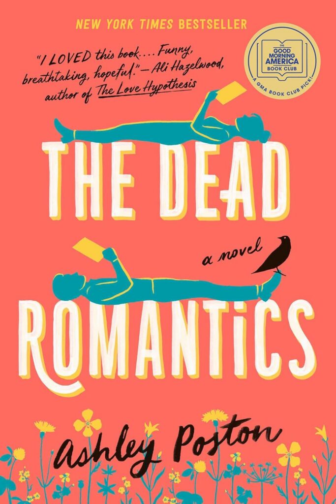 Cover of The Dead Romantics. Coral background, with a woman lying on the words "The Dead" holding a book and a man lying on the word "Romantics" holding the same book. There is a black bird on his foot. At the bottom of the cover are yellow flowers.